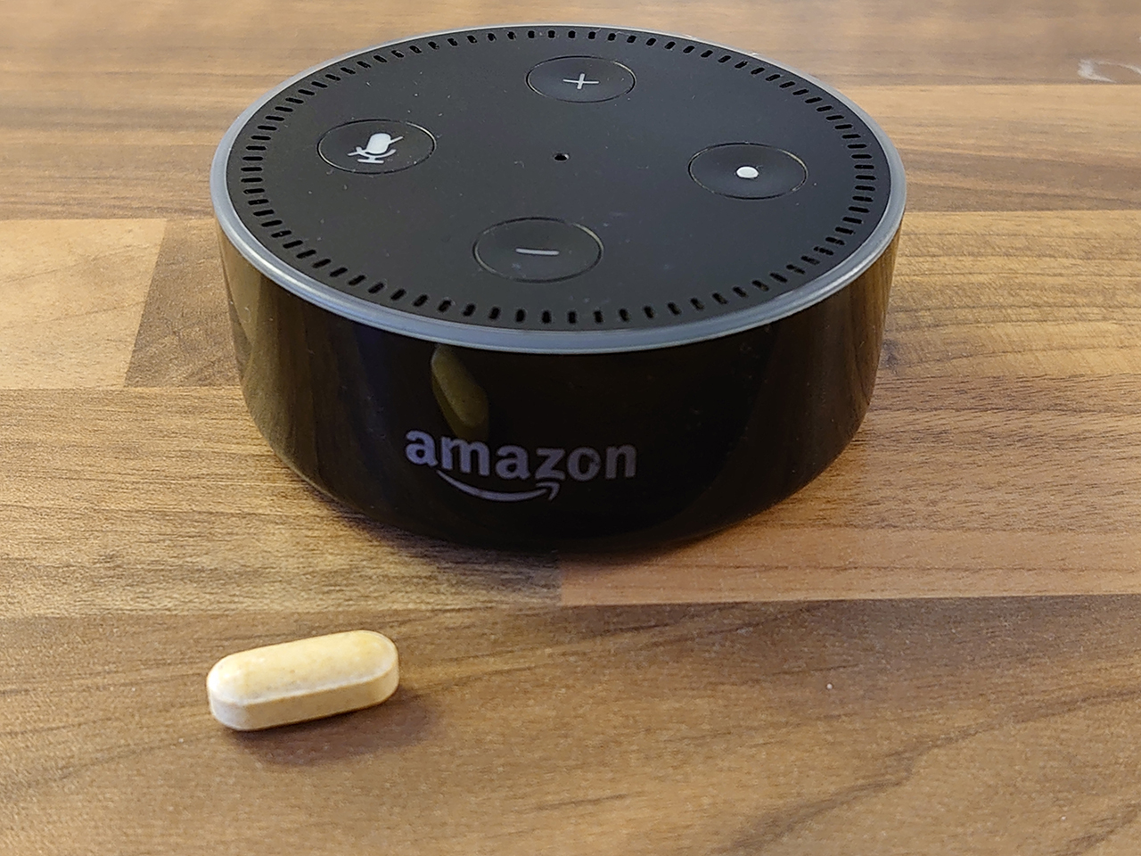 Amazon Dot running Alexa next to a pill